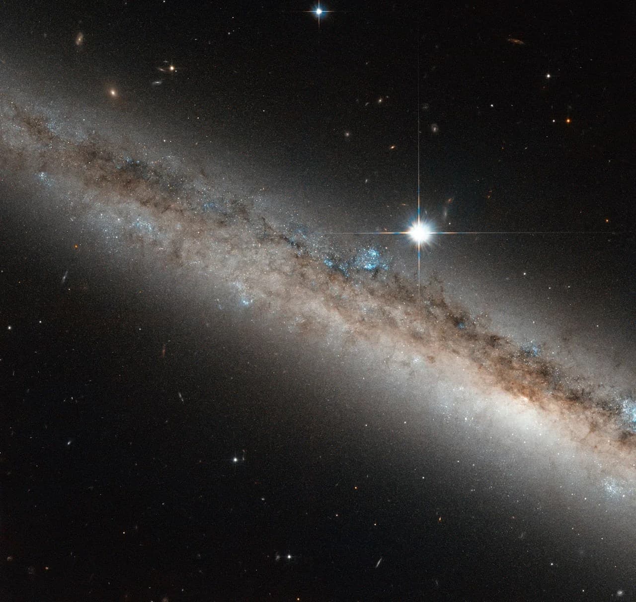 Hubble Views a Spiral Galaxy Crowned by a Star
