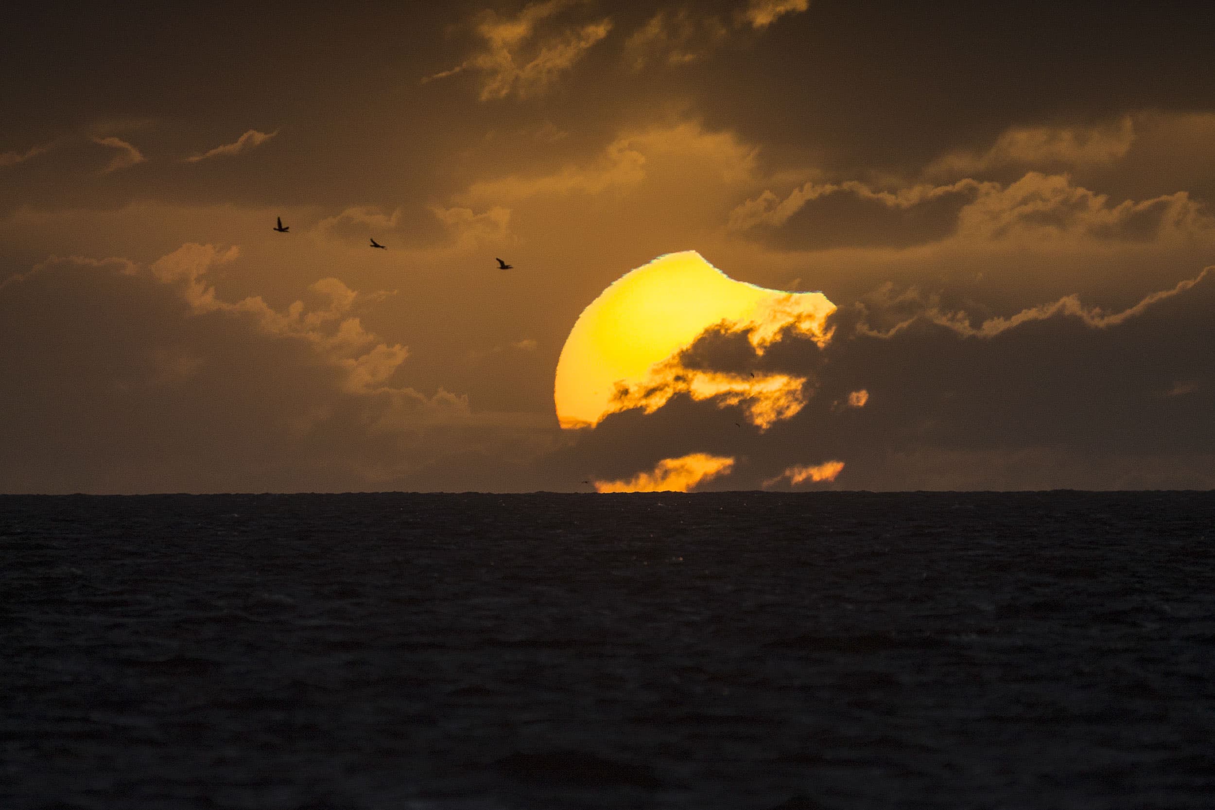 APOD: 2014 April 30 – A Partially Eclipsed Setting Sun